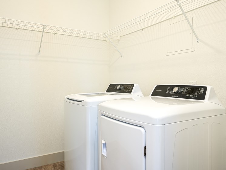 Two white washing machines in a laundry room.